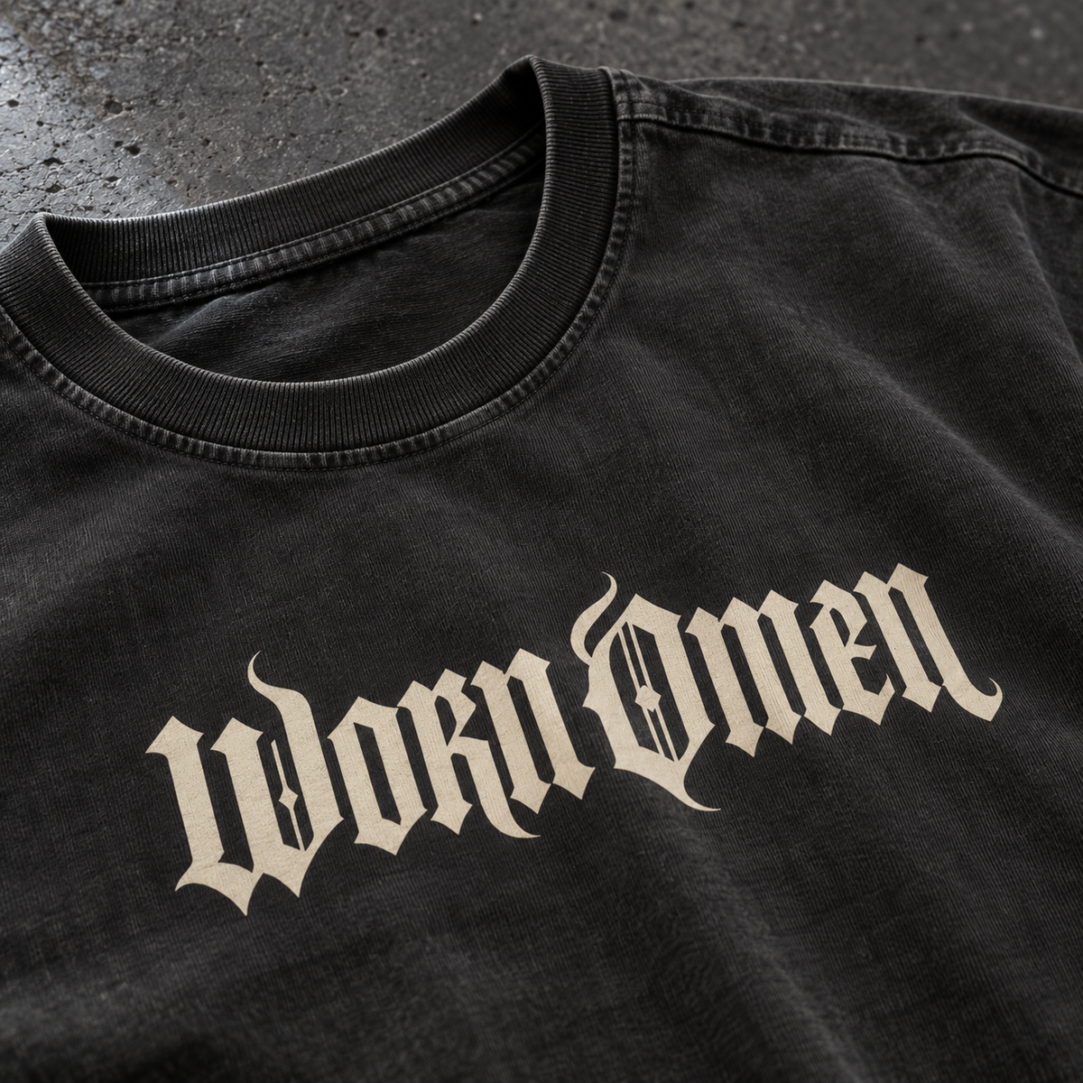 Close-up of the WORN OMEN Signature Tee neckline and bone gothic wordmark