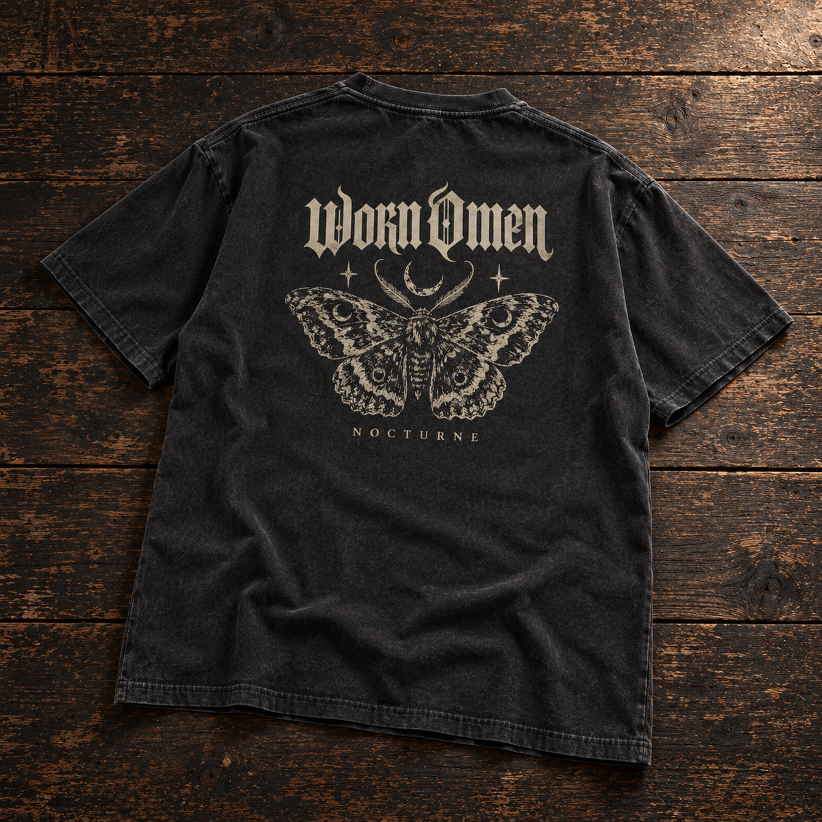 WORN OMEN Nocturne washed-black oversized tee, back moth print laid on dark timber